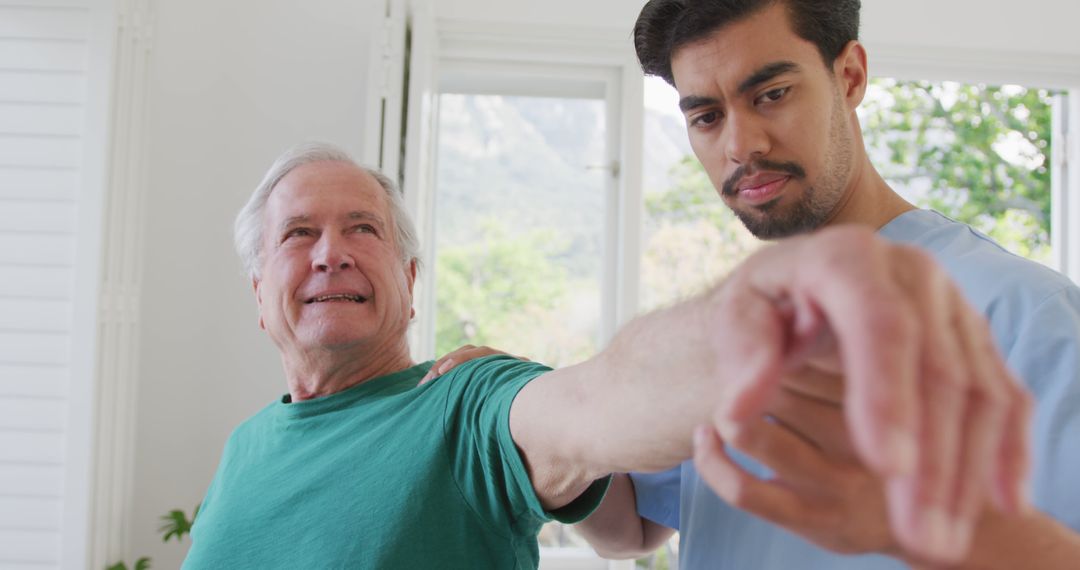 Physical therapist assisting senior man with arm exercise at home - Free Images, Stock Photos and Pictures on Pikwizard.com