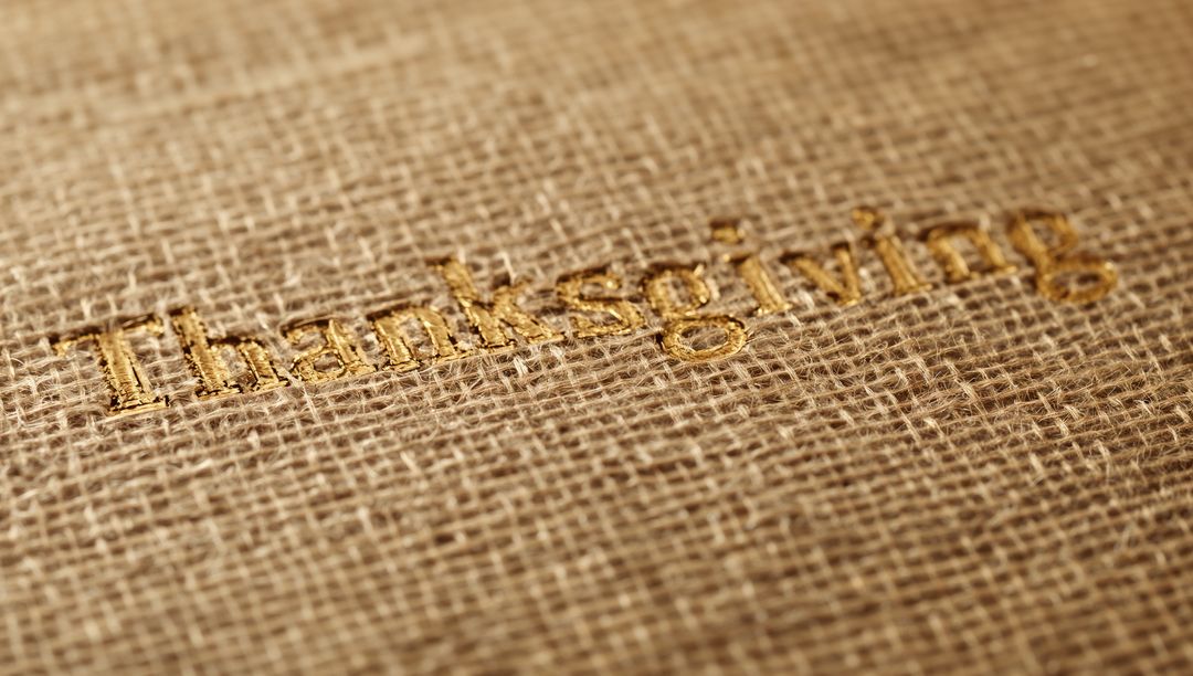 Rustic gold Thanksgiving embroidery on burlap fabric macro texture for holiday design