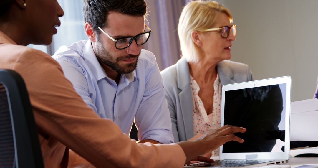 Diverse Professional Team Collaborating on Laptop