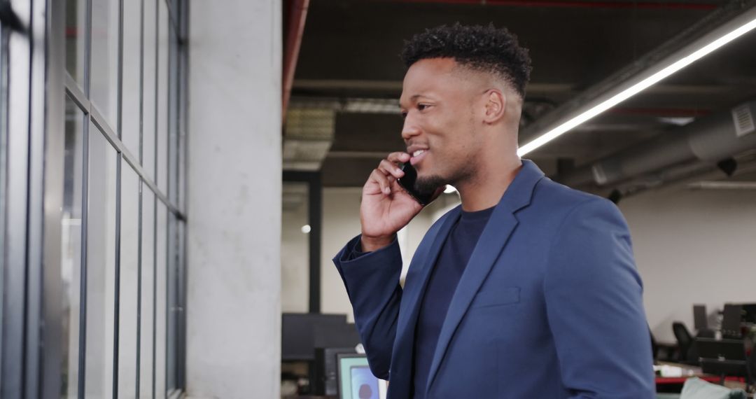 Confident Businessman Engaging in Phone Call in Modern Office