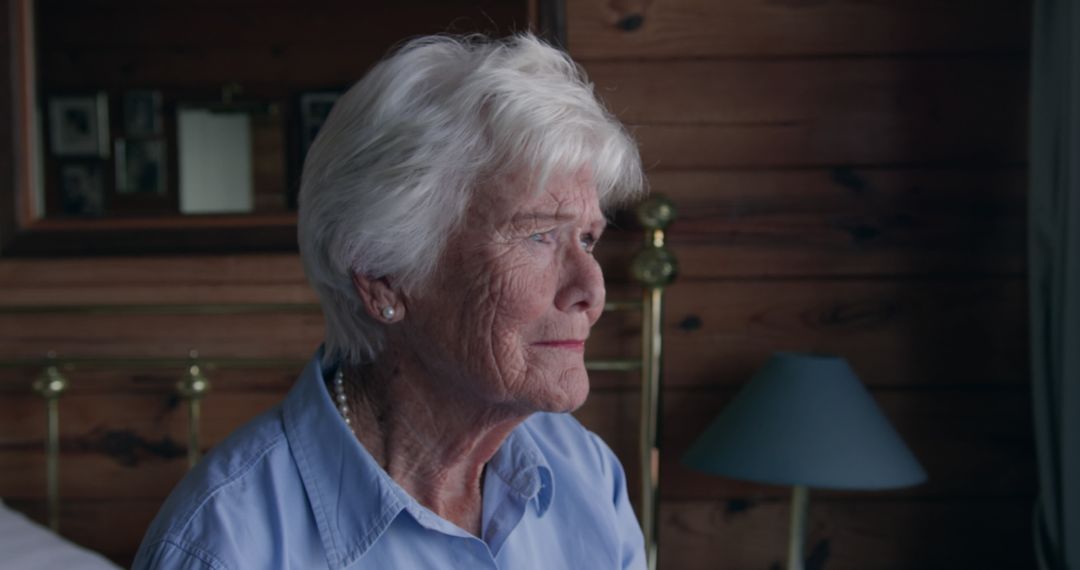 Reflective Senior Woman by Window in Cozy Home Setting