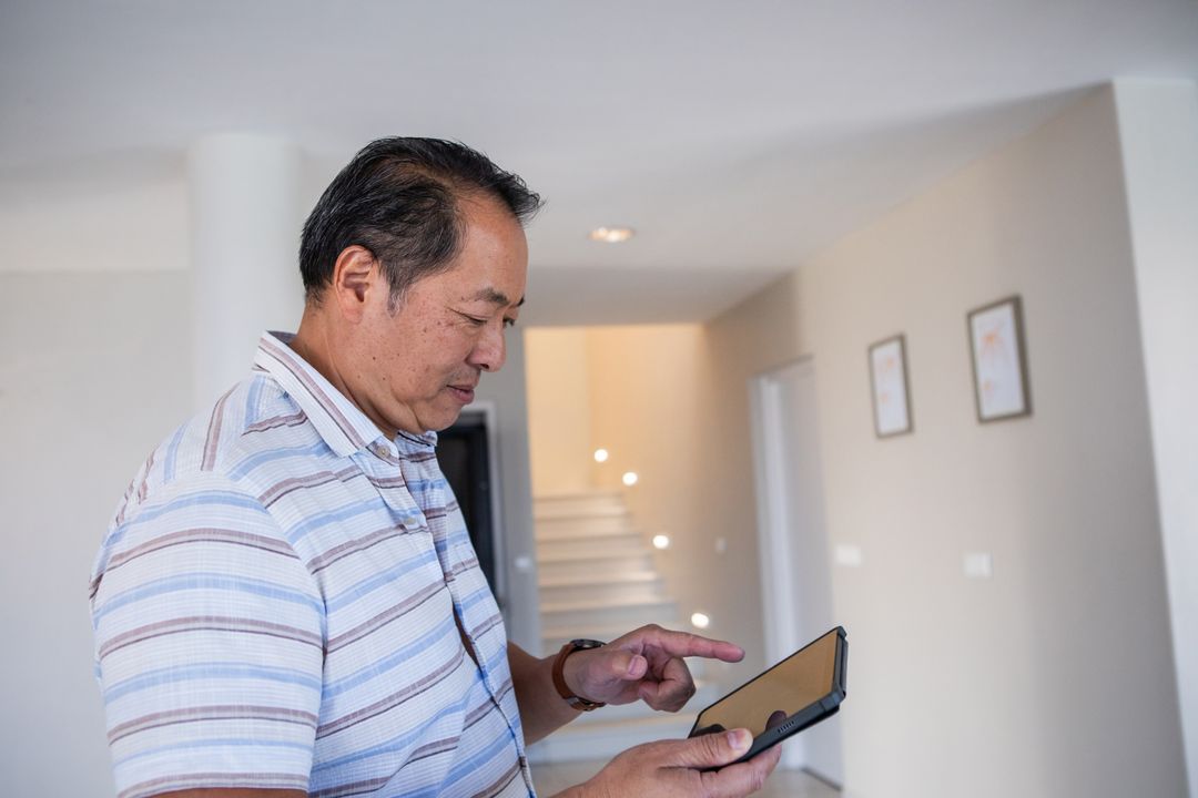 Middle-Aged Man Using Tablet in Minimalist Modern Interior