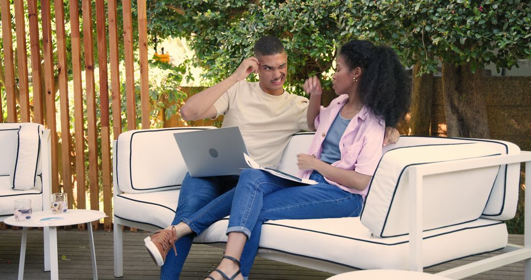 Relaxed Couple Engaging with Technology in Garden Courtyard