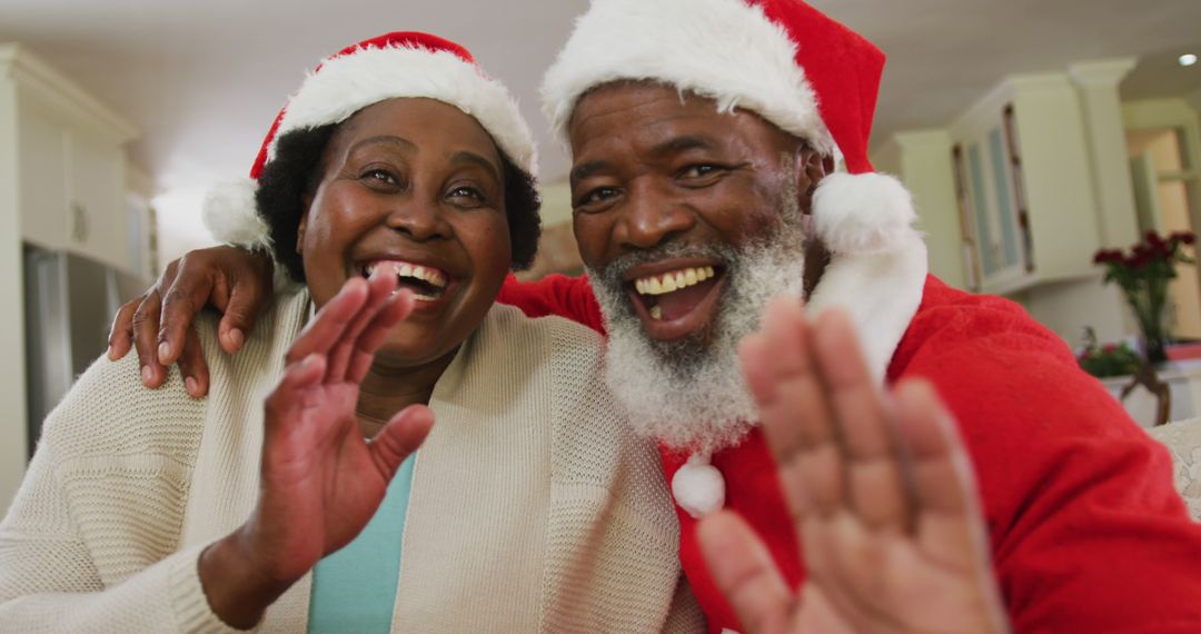 Happy Elderly Couple Waving and Smiling in Santa Hats - Free Images, Stock Photos and Pictures on Pikwizard.com