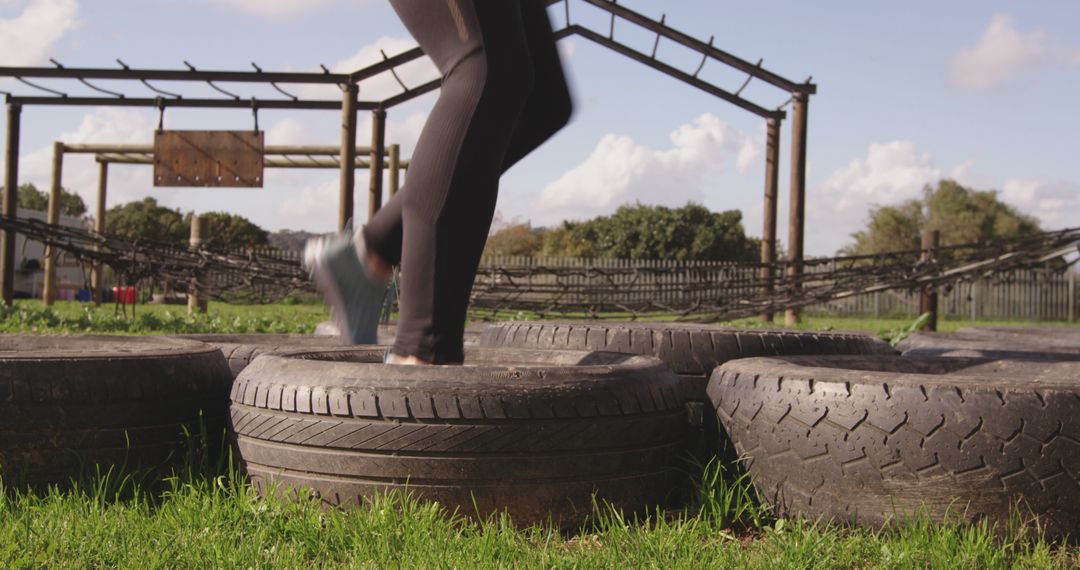 Person Navigating Tire Obstacle Course Outdoors for Fitness Training - Free Images, Stock Photos and Pictures on Pikwizard.com