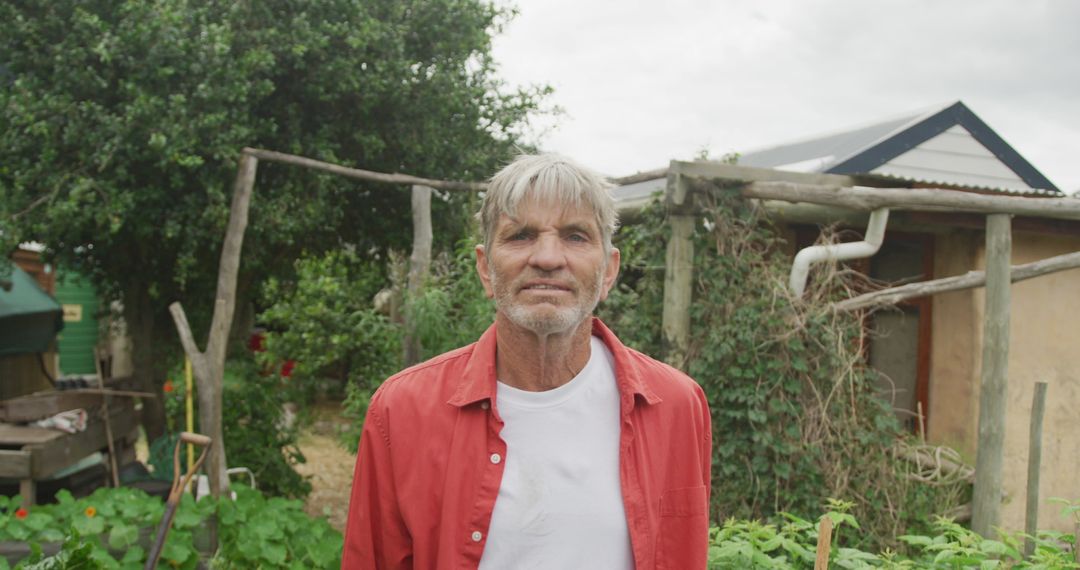Senior Man Enjoying Gardening in Lush Backyard