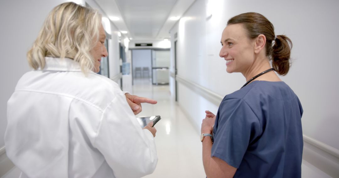 Healthcare Professionals Collaborating in Hospital Corridor - Free Images, Stock Photos and Pictures on Pikwizard.com