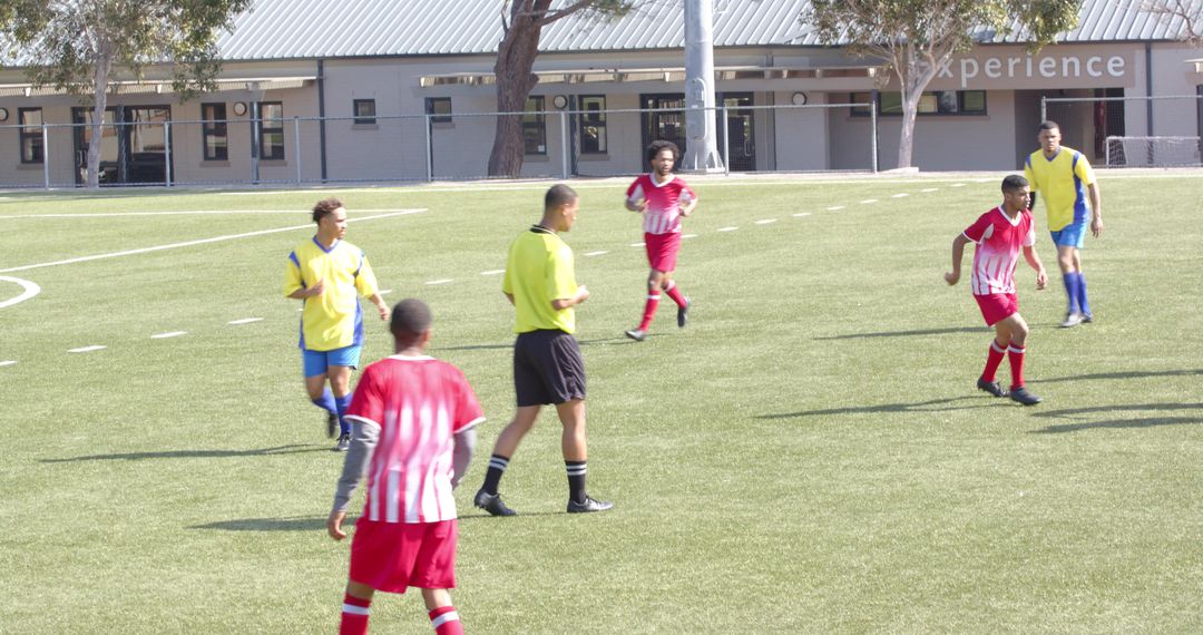 Youth Soccer Match with Players and Referee on Field