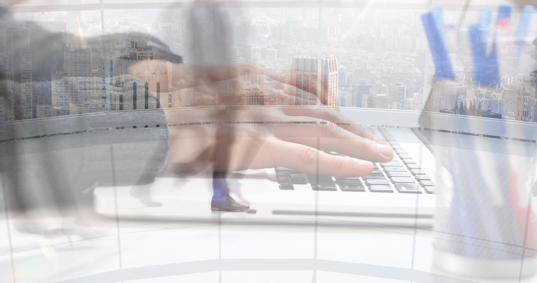 Hands Typing on Laptop Amid Fast-Paced Office Environment