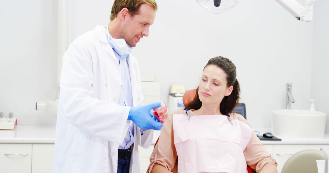 Dentist Explaining Procedure to Female Patient in Dental Clinic - Free Images, Stock Photos and Pictures on Pikwizard.com