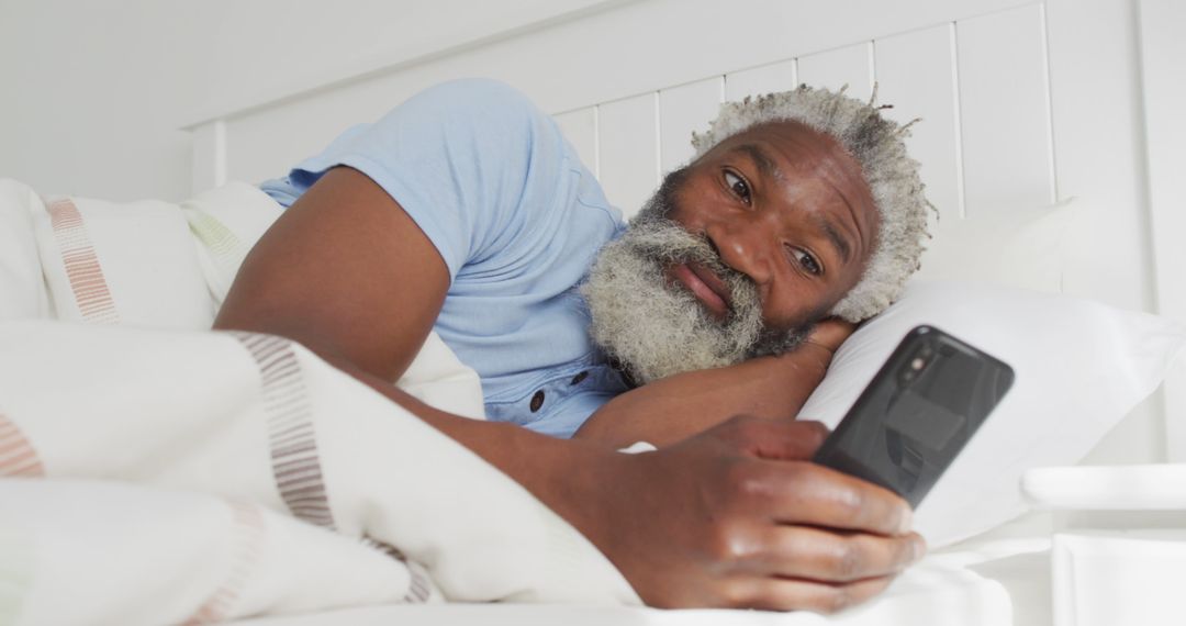 Senior Man Relaxing in Bed Using Smartphone for Communication - Free Images, Stock Photos and Pictures on Pikwizard.com