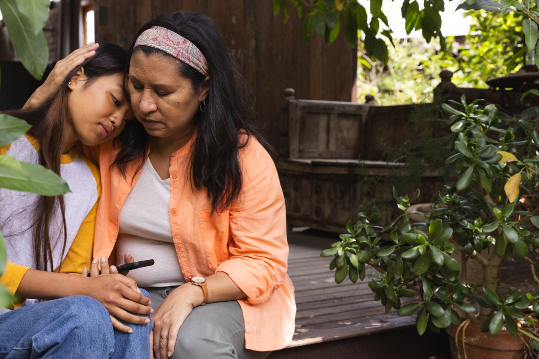 Mother Comforting Daughter in Tranquil Backyard Setting