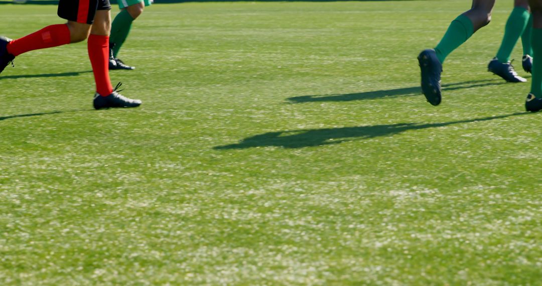 Football Players Running on Sunny Field During Match - Free Images, Stock Photos and Pictures on Pikwizard.com