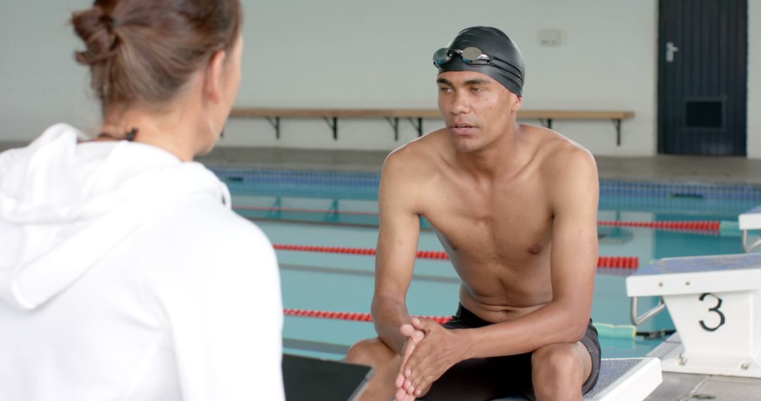 Swimming Coach Providing Feedback to Athlete Poolside Discussion