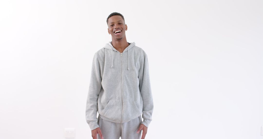 Smiling Young Man in Gray Hoodie Expressing Confidence