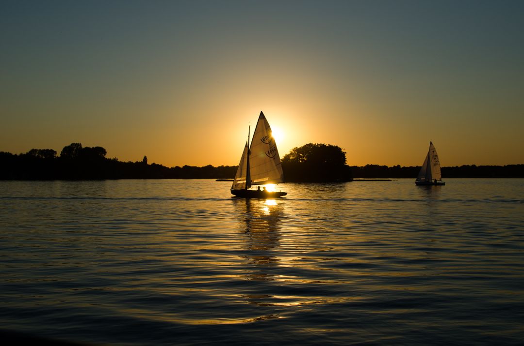 Sailboats on Tranquil Lake During Sunset - Free Images, Stock Photos and Pictures on Pikwizard.com