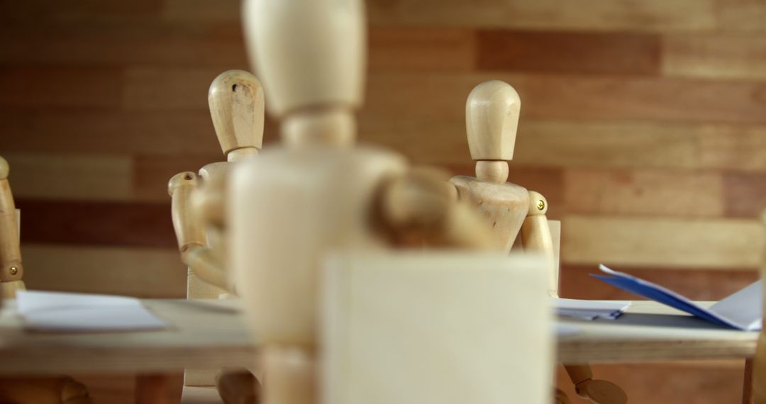 Wooden Mannequins Sitting at a Table in Discussion - Free Images, Stock Photos and Pictures on Pikwizard.com