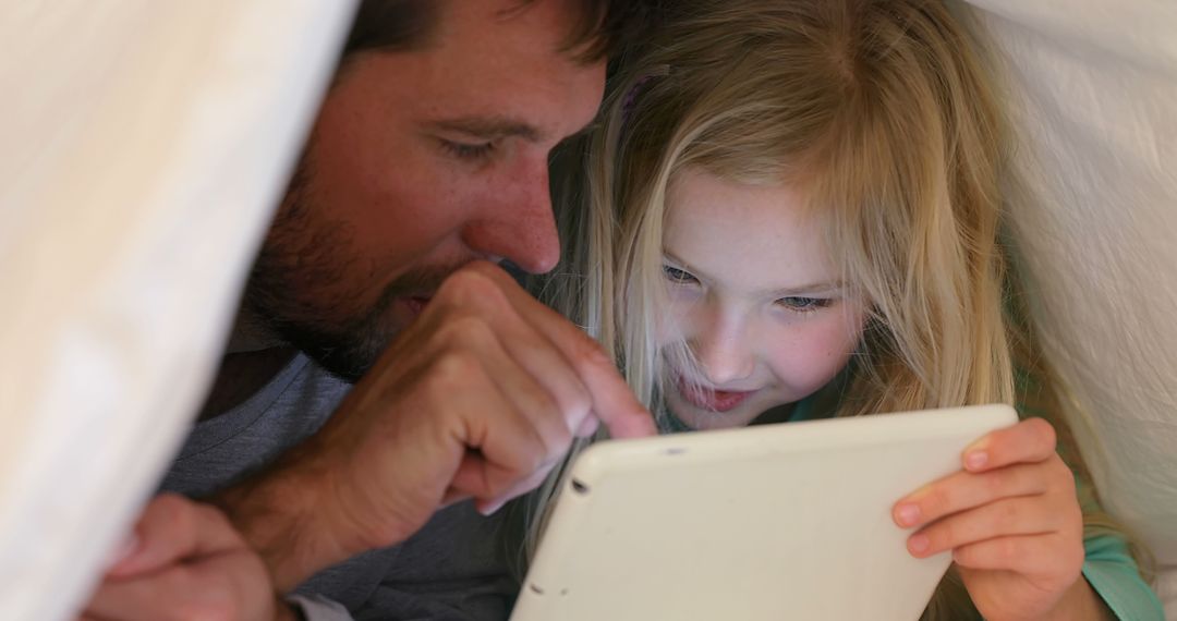 Father and Daughter Enjoying Tablet Under Blanket - Free Images, Stock Photos and Pictures on Pikwizard.com