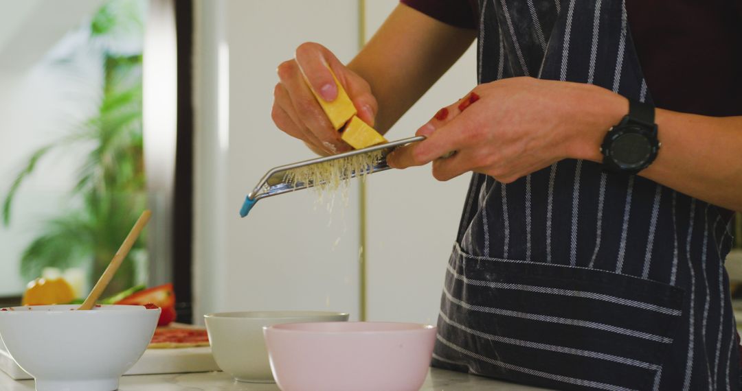 Person Grating Cheese in Modern Kitchen - Free Images, Stock Photos and Pictures on Pikwizard.com