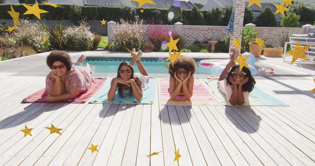 Four women sunbathing on colorful towels by backyard pool enjoying summer sunshine and relaxing