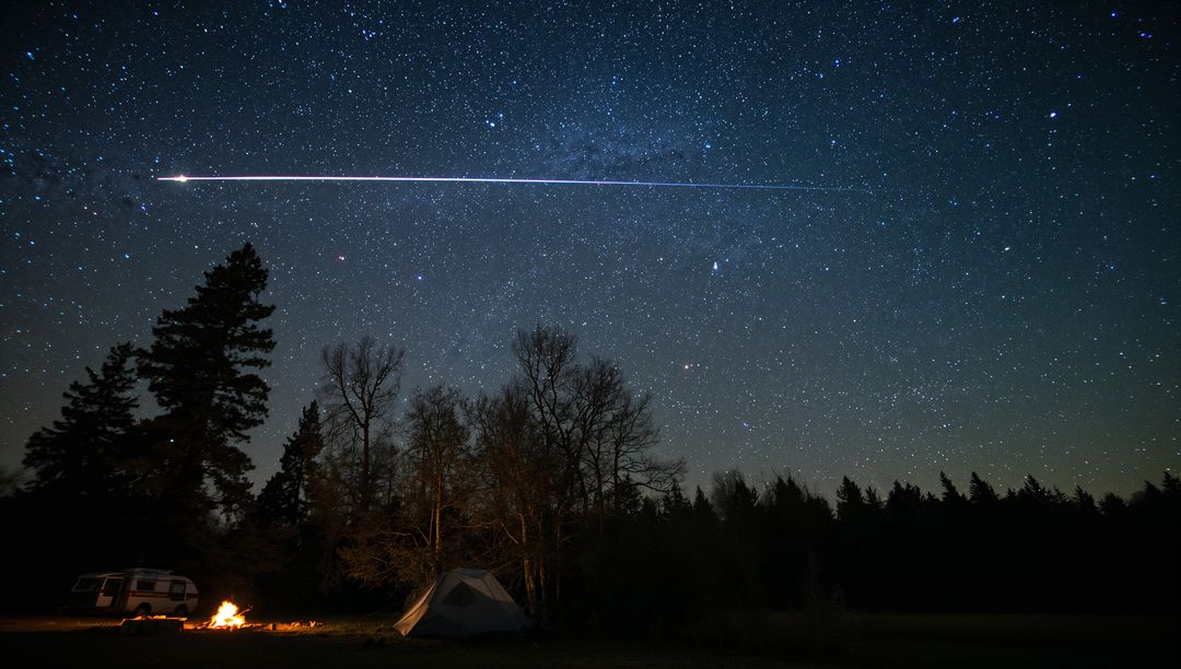 Campfire Illuminating Tent Under Starry Sky with Meteor Streak and Camper Van Nightscape