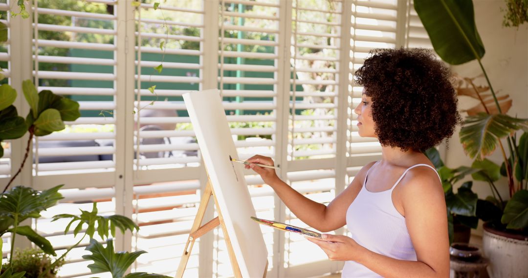 Artist Creating Vibrant Painting in Sunlit Studio