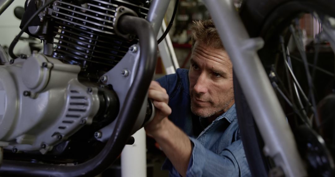 Man Repairing Motorcycle Engine in Workshop - Free Images, Stock Photos and Pictures on Pikwizard.com