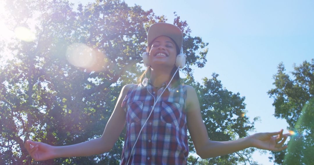 Smiling Young Woman Enjoying Music Outdoors in Nature - Free Images, Stock Photos and Pictures on Pikwizard.com