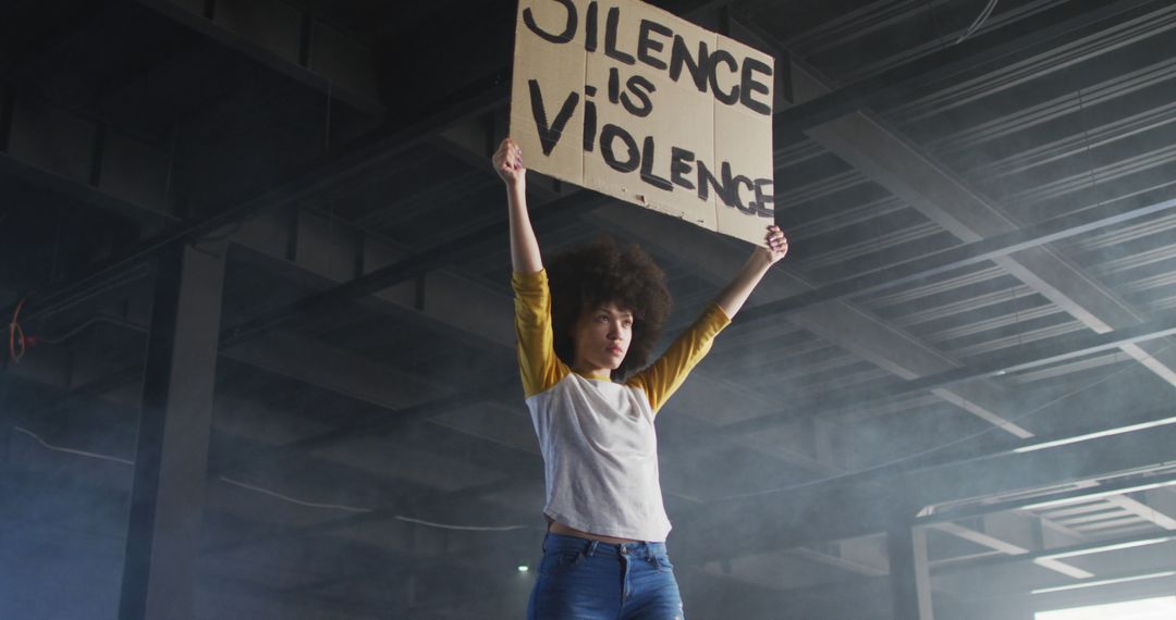 Diverse Protester Holding Silence is Violence Sign in Industrial Building - Free Images, Stock Photos and Pictures on Pikwizard.com