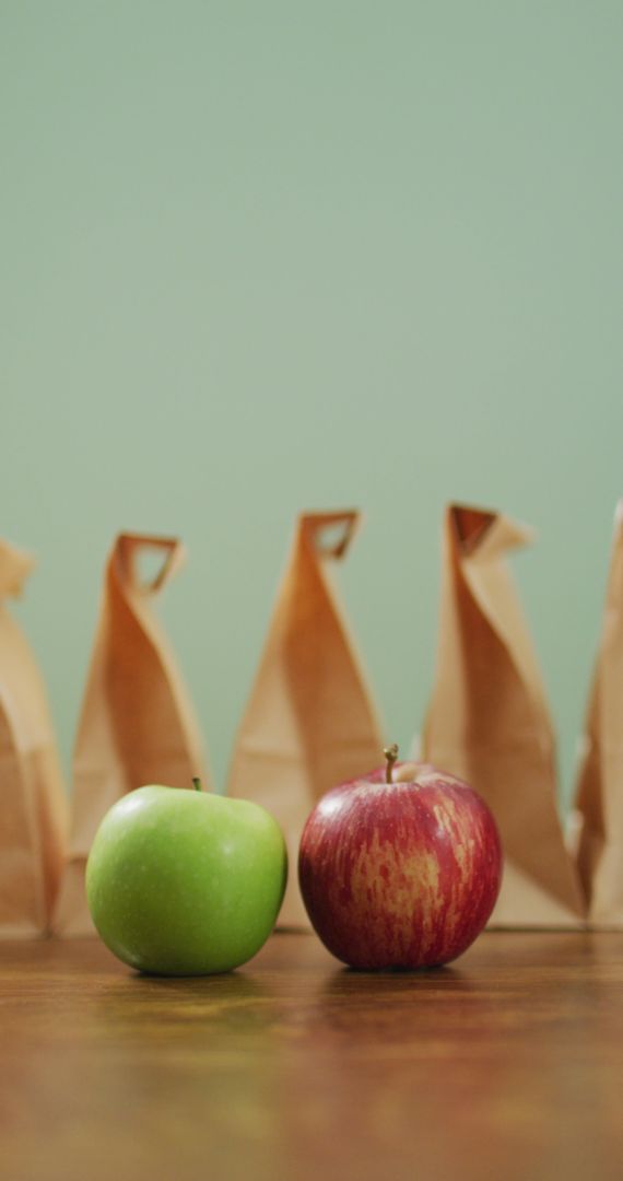Colorful Apples with Packed Lunches Against Green Backdrop