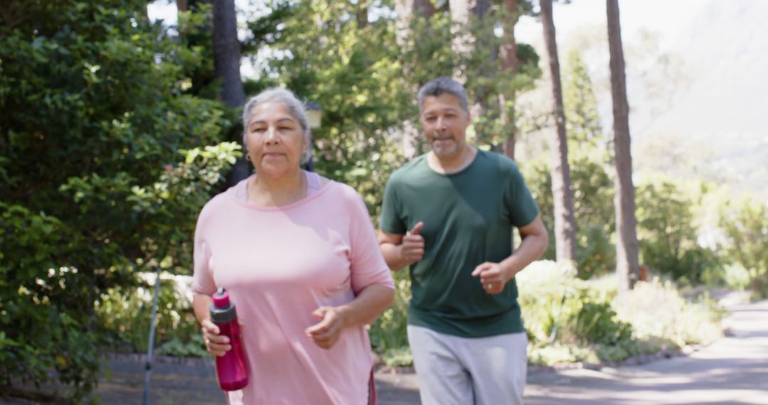 Senior couple jogging in park on sunny day - Free Images, Stock Photos and Pictures on Pikwizard.com