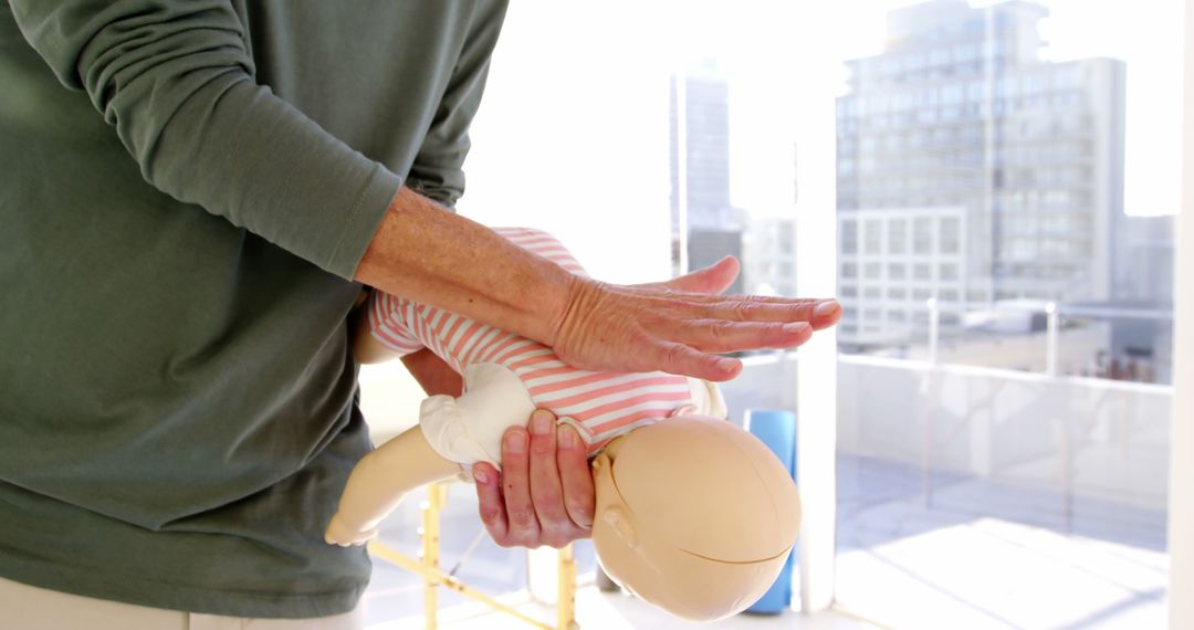 Person Practicing Infant CPR on Dummy in Urban Setting - Free Images, Stock Photos and Pictures on Pikwizard.com