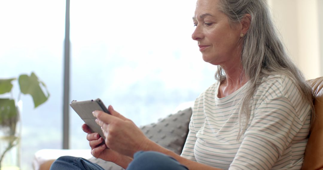 Senior Woman Using Smartphone, Relaxed at Home, Slow Motion