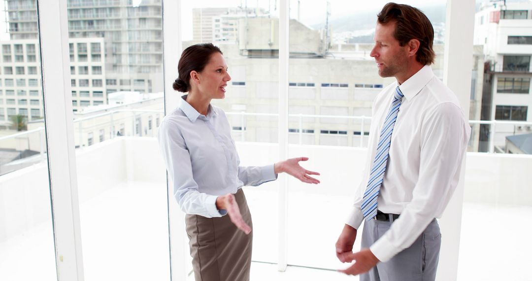 Business Colleagues Discussing Office Strategies by Cityscape Window