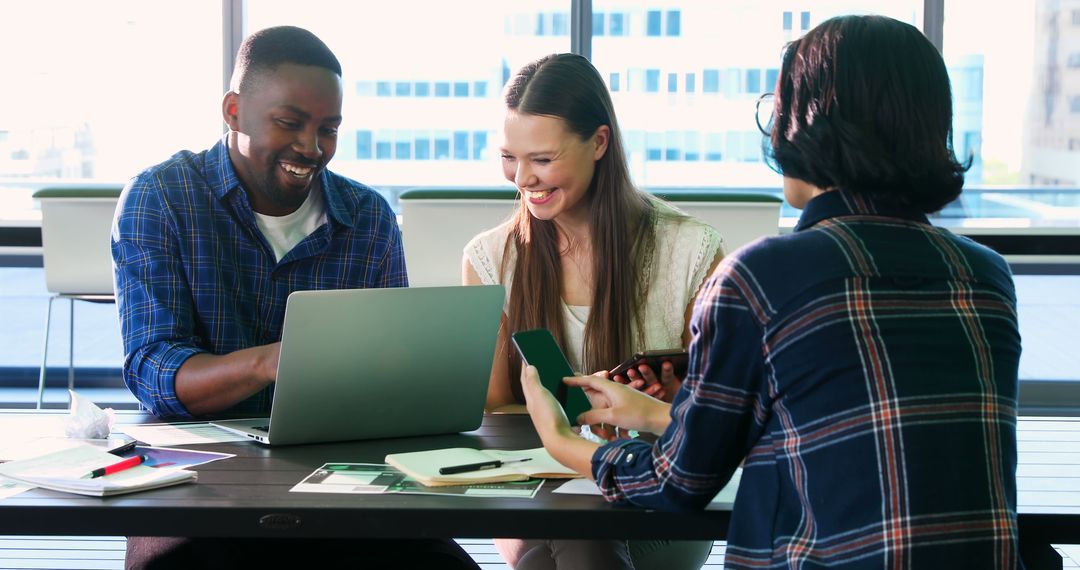 Multiracial Team Collaborating on Laptop in Modern Office Space