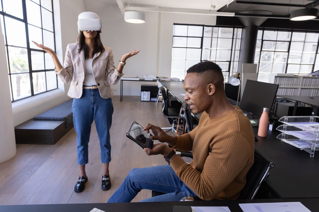 Diverse Coworkers Exploring VR and Collaborating with Tablet in Modern Open-Plan Office