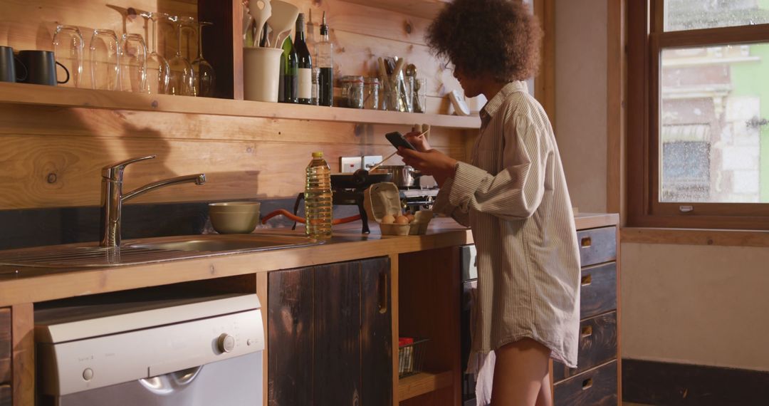 Woman Preparing Breakfast in Cozy Kitchen with Wooden Interiors - Free Images, Stock Photos and Pictures on Pikwizard.com