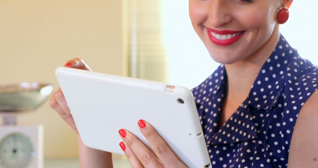 Woman Engaging with Digital Tablet Wearing Polka Dot Dress - Free Images, Stock Photos and Pictures on Pikwizard.com