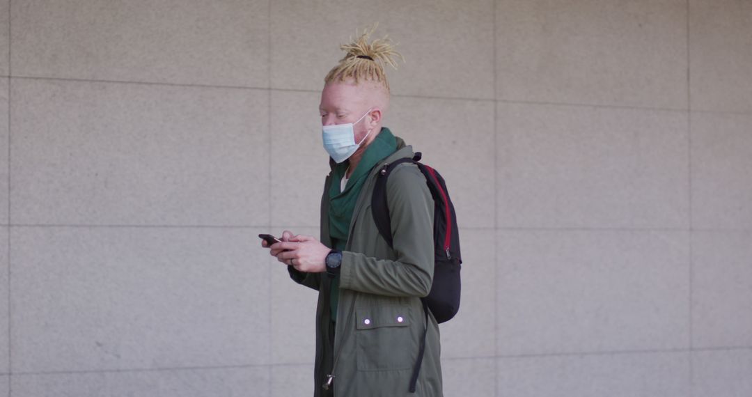 Man with Dreadlocks Texting while Wearing Face Mask Outdoors - Free Images, Stock Photos and Pictures on Pikwizard.com