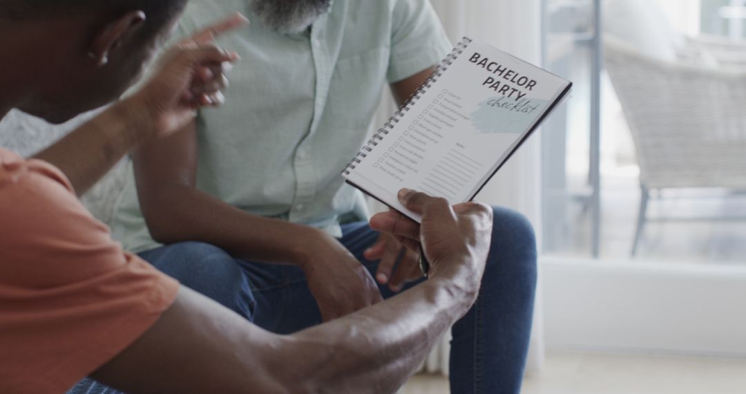 Men Discussing Bachelor Party Plans at Home with Checklist