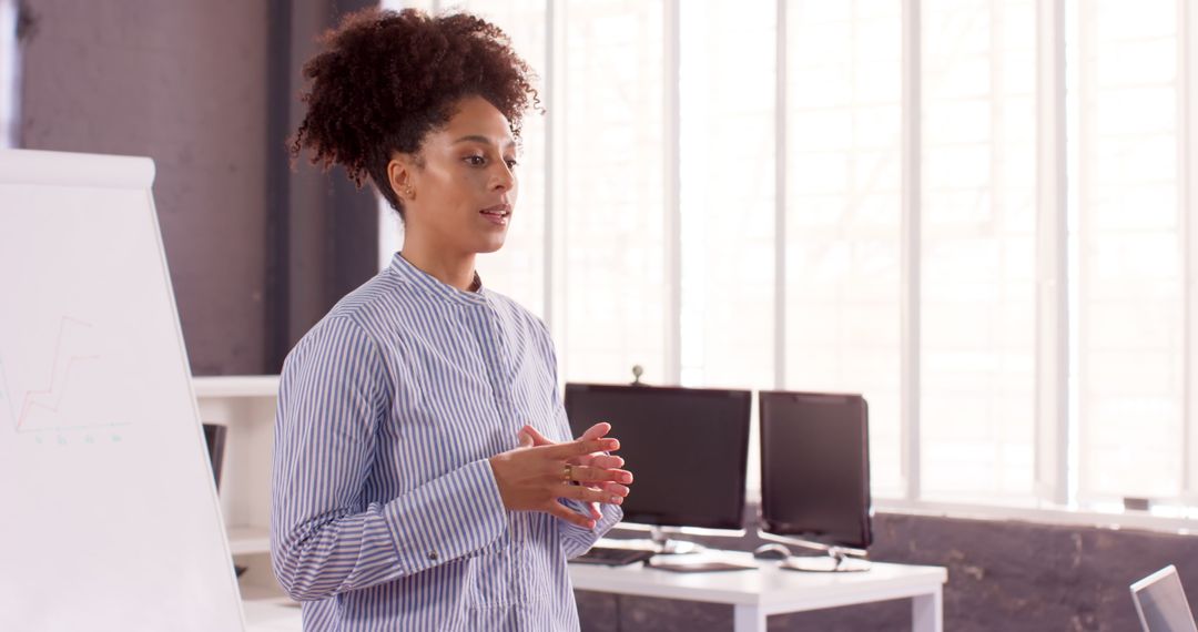 Businesswoman Leading Meeting near Whiteboard in Sunlit Office