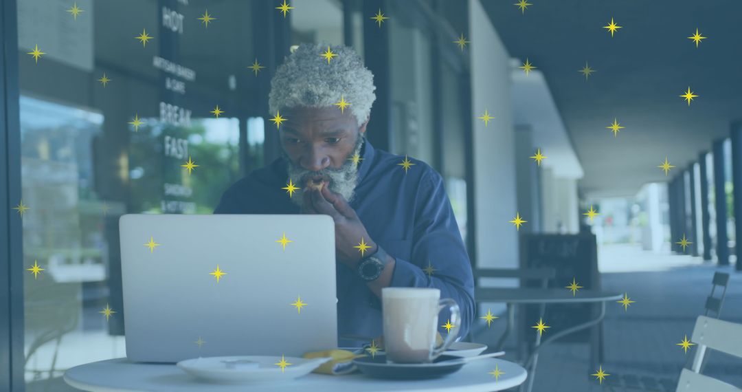 African American Man Using Laptop at Cafe with Overlay of Stars