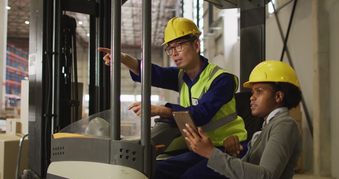 Warehouse Workers Discussing Logistics on Forklift - Free Images, Stock Photos and Pictures on Pikwizard.com