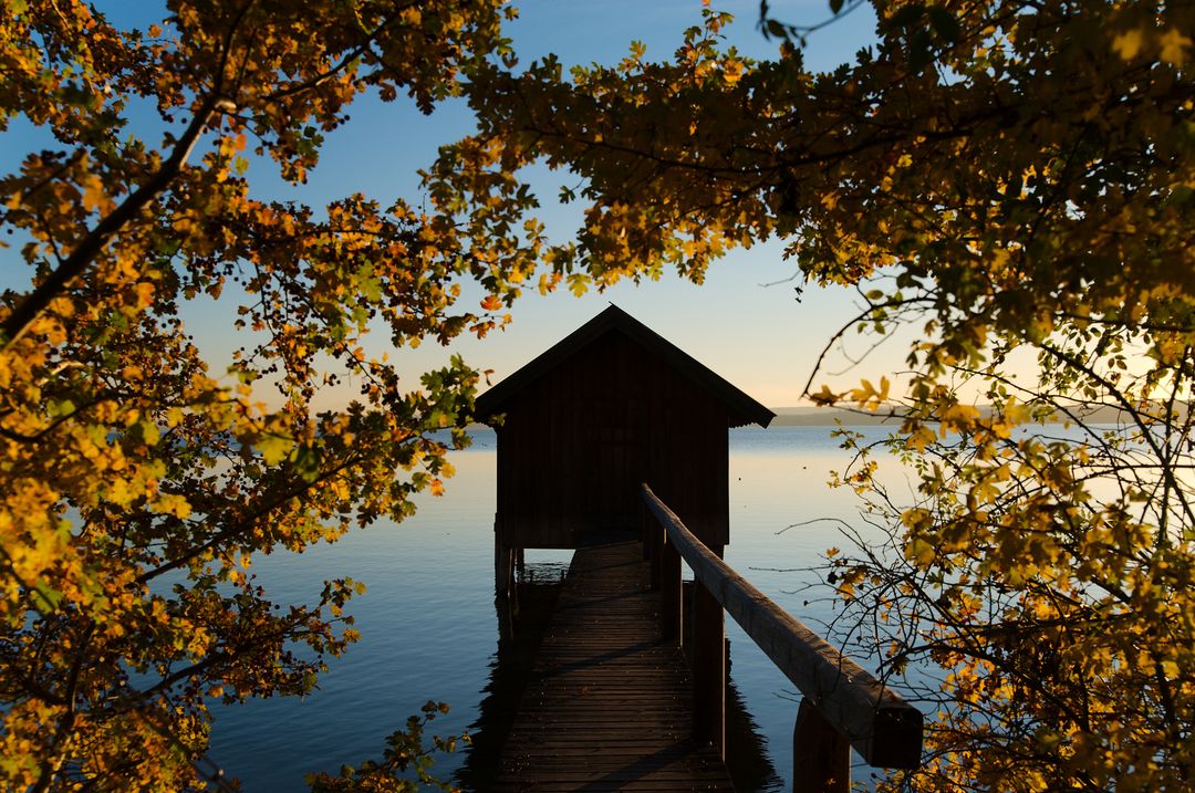 Secluded Lake House Pier Surrounded by Autumn Foliage at Sunset - Free Images, Stock Photos and Pictures on Pikwizard.com