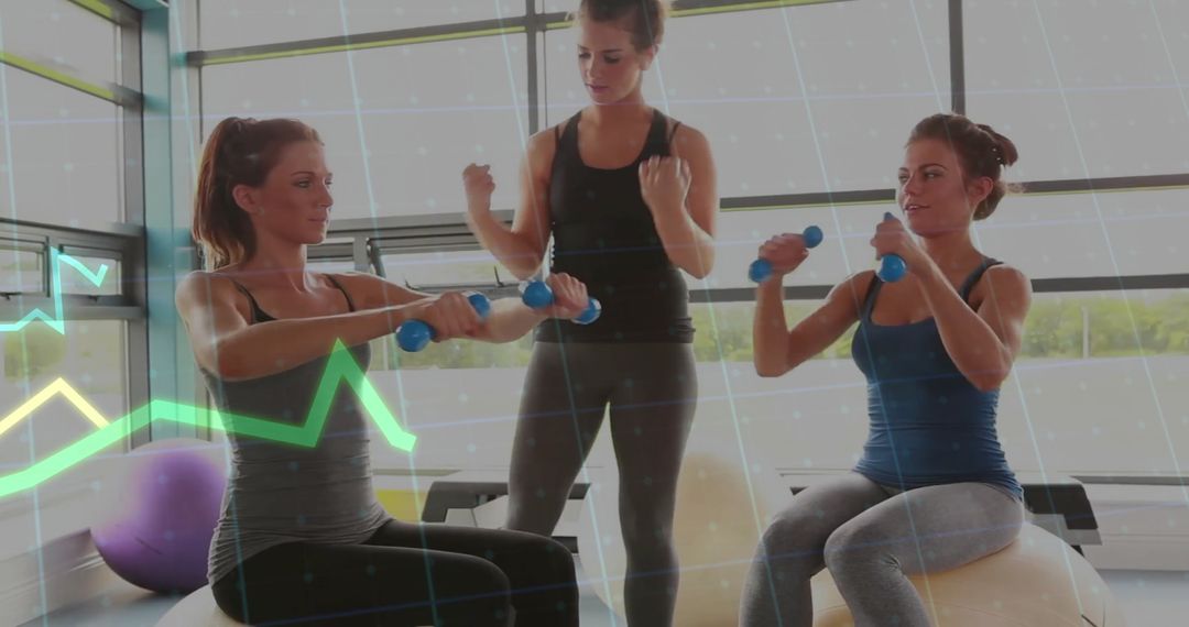 Women Exercising with Trainer Using Dumbbells and Balance Balls in Gym
