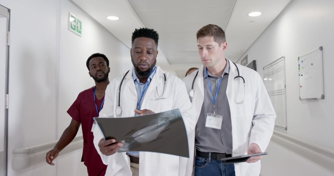 Multiracial Medical Professionals Reviewing X-rays in Hospital Corridor - Free Images, Stock Photos and Pictures on Pikwizard.com