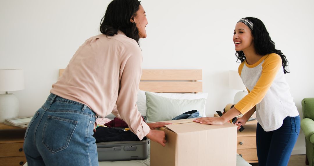 Mother and Daughter Packing Boxes Together at Home for Relocation