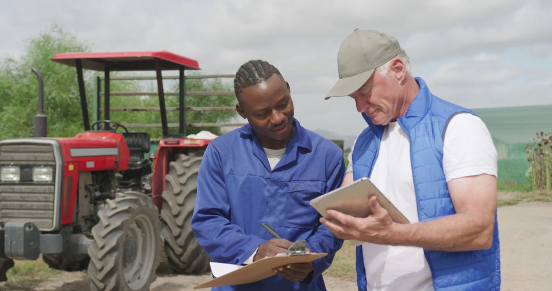 Multi-Ethnic Farmers Working with Tractors and Digital Tablets on Farmland - Free Images, Stock Photos and Pictures on Pikwizard.com