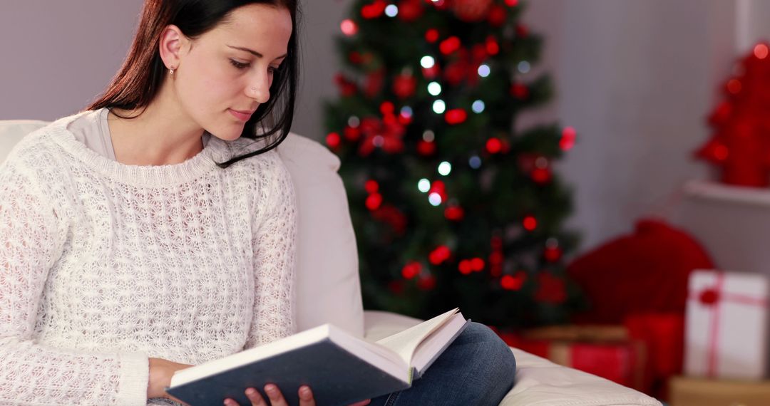 Young Woman Enjoying Reading Book Near Christmas Tree - Free Images, Stock Photos and Pictures on Pikwizard.com