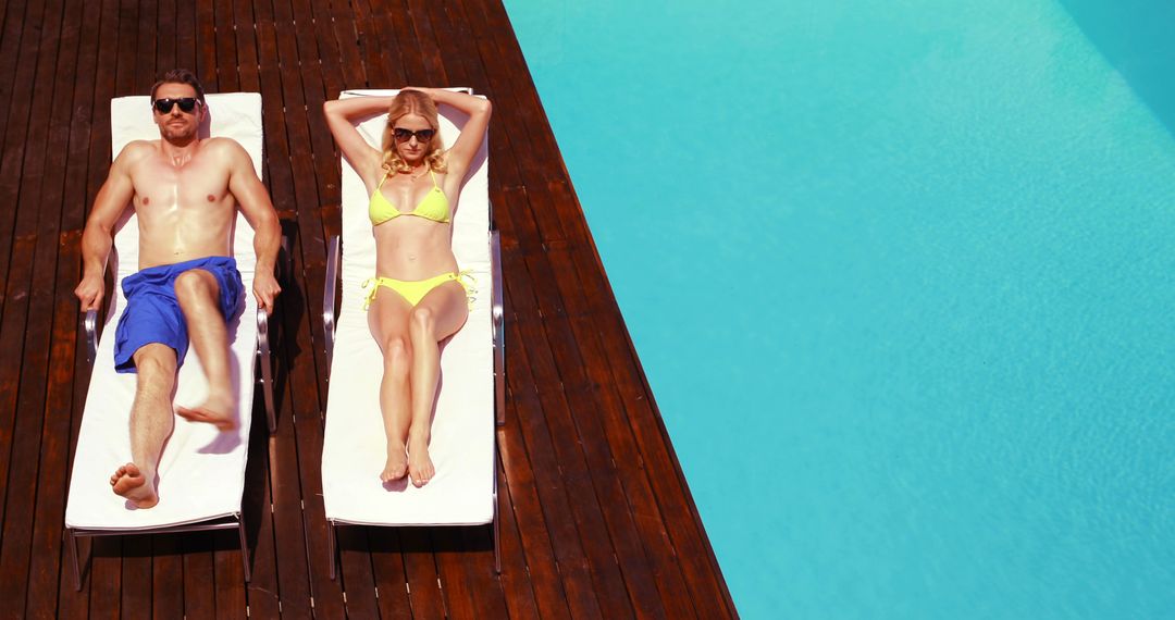 Couple Relaxing on Sun Loungers by Pool on Sunny Day - Free Images, Stock Photos and Pictures on Pikwizard.com